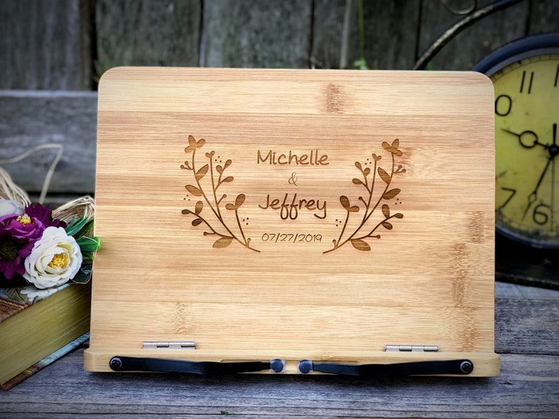 May include: A wooden book stand with a personalized inscription. The inscription reads "Michelle & Jeffrey 07/27/2019" with a floral design.