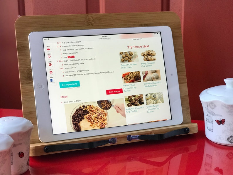 May include: A tablet displaying a recipe for chocolate chip cookies with a list of ingredients and steps. The tablet is on a wooden stand with a white ceramic sugar bowl and two salt shakers in the foreground. The recipe includes 1/4 cup granulated sugar, 1/2 cup packed brown sugar, 1 cup butter or margarine, softened, 1 teaspoon vanilla, 1 1/4 cups Gold Medal&reg; all-purpose flour, 1 teaspoon baking soda, 1/2 teaspoon salt, 1 cup coarsely chopped nuts, 1 package (12 oz) semisweet chocolate chips (2 cups).