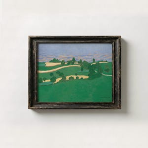 May include: A framed landscape painting featuring rolling green hills, patches of yellow fields, and scattered dark green trees under a soft blue sky. The artwork is enclosed in a dark, weathered wooden frame with a visible texture and grain.