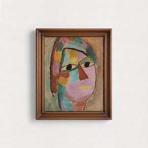 May include: A framed painting of a stylized human face featuring a patchwork of muted colors including pink, blue, green, and brown. The face has dark almond-shaped eyes, a triangular nose, and a yellow mouth. The signature J. Jawlensky is visible.