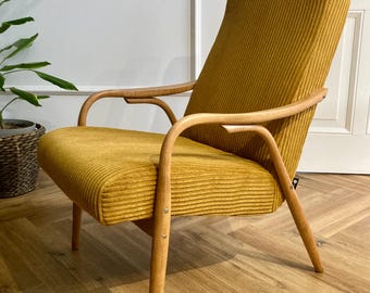May include: A mustard yellow armchair with a ribbed fabric upholstery and wooden legs. The chair has a high back and curved arms.