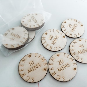 May include: A set of six wooden round tokens with the words "Screen Time" and different time increments in minutes. The tokens are in a clear plastic bag.