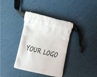 May include: White drawstring bag with black drawstrings and the text "YOUR LOGO" printed in black.