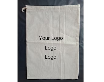 Op de afbeelding: Een witte katoenen trekkoordtas met de tekst "Your Logo" en "Logo" twee keer herhaald.