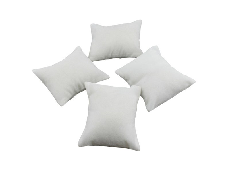 May include: Four white, square-shaped, fabric-covered cushions. The cushions are arranged in a star shape.