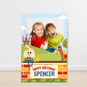 May include: A photo booth prop featuring a cartoon egg character, a horse, and a castle. The prop has a brick wall with the text "Happy Birthday Spencer".