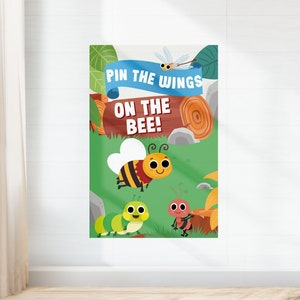 May include: A colorful game board for a "Pin the Wings on the Bee" game. The board features a cartoon bee, a caterpillar, and an ant on a green background with a brown log and a blue banner that says "Pin the Wings on the Bee!"