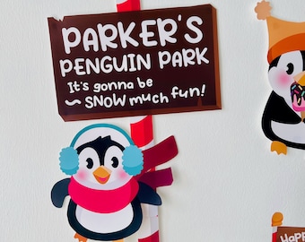 May include: A brown sign with the text "Parker's Penguin Park" and the phrase "It's gonna be ~SNOW much fun!" A cartoon penguin with a red scarf and blue earmuffs is on a red and white striped pole.