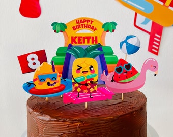 May include: A chocolate cake decorated with a summer-themed party scene. The cake is topped with a sign that says "Happy Birthday Keith" and a number 8. There are also several other decorations, including a pineapple, a watermelon, a flamingo, and a beach ball.