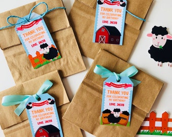 Puede incluir: Cuatro bolsas de papel marrón con lazos azules y etiquetas de agradecimiento. Las etiquetas están decoradas con una oveja negra de dibujos animados, un granero rojo y el texto "¡Gracias por celebrar mi cumpleaños! Con cariño, Jacob".