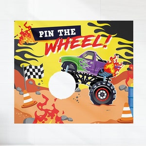 Puede incluir: Un tablero de juego amarillo y negro con las palabras "Pin the Wheel!" en rojo. Un camión monstruo morado con llamas está conduciendo sobre un círculo blanco. El juego está diseñado para una fiesta.