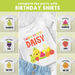 May include: A set of nine white t-shirts with colorful fruit designs and the text "Tutti-Cutie's" and "Twoti-Frutti Daisy".