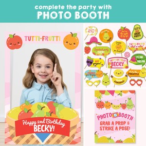 Tutti Frutti Party photo booth backdrop with a basket of fruit and the text "Happy 2nd Birthday Becky!"  A separate sign says "Photo Booth Grab a Prop & Strike a Pose!"  There are 20 colourful fruit-themed photo booth props.