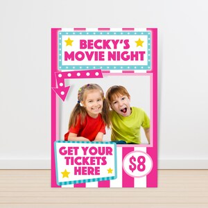 May include: A pink and blue photo booth backdrop with the text "Becky's Movie Night" and a picture frame with two children in it. The text "Get Your Tickets Here" and "$8" are also on the backdrop.