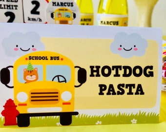 Può includere: Un autobus scolastico giallo con un autista di cartoni animati sorridente e il testo "SCHOOL BUS" sul lato. L'autobus è su un cartello bianco con una nuvola blu e il testo "HOTDOG PASTA" in nero.