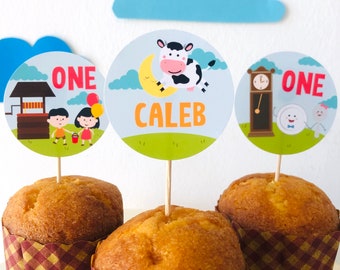 May include: Three cupcakes with brown and white checkered wrappers topped with round paper cupcake toppers. The toppers feature illustrations of a cow, a clock, and a well. The toppers also include the text "ONE" and "Caleb".