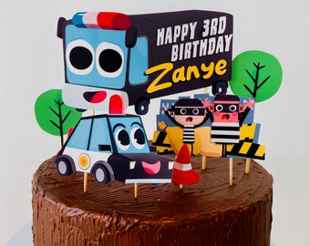 Könnte beinhalten: Ein Schokoladenkuchen, der mit einem Polizeiauto, zwei Strichmännchen in gestreiften Hemden und einem Schild mit der Aufschrift "Happy 3rd Birthday Zanye" verziert ist.