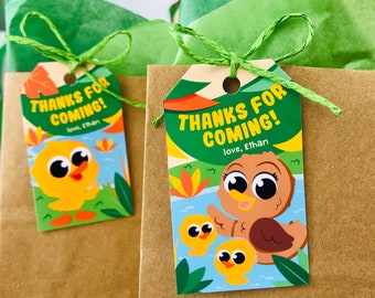 May include: Two gift tags with the text "THANKS FOR COMING!" and "love, Ethan". The tags feature cartoon ducks and ducklings in a pond setting, with green and orange accents. The tags are tied to brown paper bags with green twine.