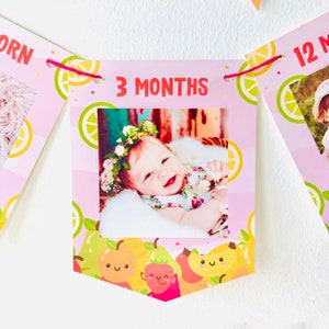 K&ouml;nnte beinhalten: Rosa-gr&uuml;ner Baby-Meilenstein-Banner mit einem Foto eines Babys mit einer Blumenkrone. Der Banner lautet "3 Monate".