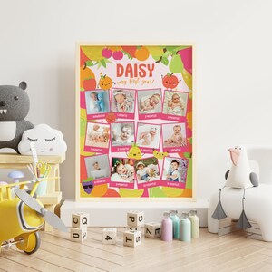 K&ouml;nnte beinhalten: Ein rosa-gelber Baby-Meilenstein-Chart mit einem Frucht-Motiv. Der Chart hat 12 Fotopl&auml;tze f&uuml;r jeden Monat des ersten Lebensjahres des Babys. Der Chart tr&auml;gt den Namen "Daisy" und den Text "very first year!" oben.