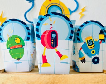 Puede incluir: Tres cajas de regalo azules y blancas con diseños de robots. Las cajas presentan un robot rojo, un robot verde y un robot azul. Las cajas son perfectas para guardar pequeñas golosinas o favores de fiesta.
