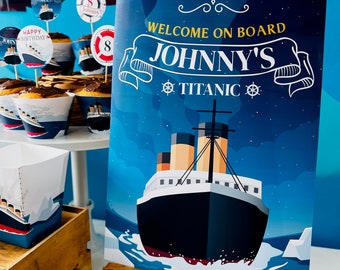 May include: A blue and white welcome sign with the text "Welcome on Board Johnny's Titanic" in a white banner with a gold anchor on each side. The sign is on a wooden easel with a blue background and a cartoon image of the Titanic ship.