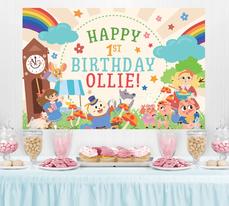May include: A colorful birthday banner with a rainbow, clouds, stars, and a clock tower. The banner says "Happy 1st Birthday Ollie!" and features cartoon characters from the story of the Three Little Pigs.