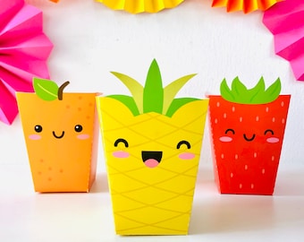 May include: Three colorful party favor boxes shaped like a pineapple, orange, and strawberry. Each box has a cute cartoon face with smiling eyes and a mouth. The boxes are perfect for holding small treats or gifts.