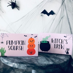May include: Two pink Halloween party signs with black text and illustrations. The first sign says "Pumpkin Squash" and features a stack of three smiling pumpkins. The second sign says "Witch's Brew" and features a black cauldron with green liquid and a black cat.