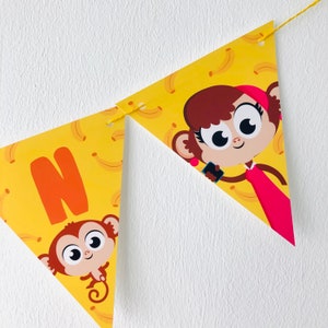 May include: A yellow triangular banner with a monkey holding a phone and a monkey with the letter N. The banner has a pattern of yellow bananas on it.