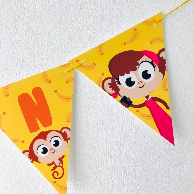 May include: A yellow triangular banner with a monkey holding a phone and a monkey with the letter N. The banner has a pattern of yellow bananas on it.