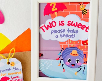 May include: A white frame with a colorful illustration of a spider wearing a hat and boots. The text "TWO is sweet please take a treat!" is written in pink and purple letters. 