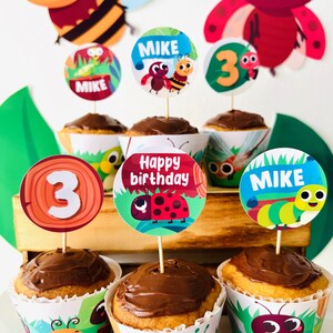 Könnte beinhalten: Sechs Cupcakes, die mit bunten Cupcake-Toppern verziert sind, die eine Marienkäfer, eine Raupe und die Zahl 3 zeigen. Die Topper enthalten auch den Namen "Mike" und den Spruch "Happy Birthday".