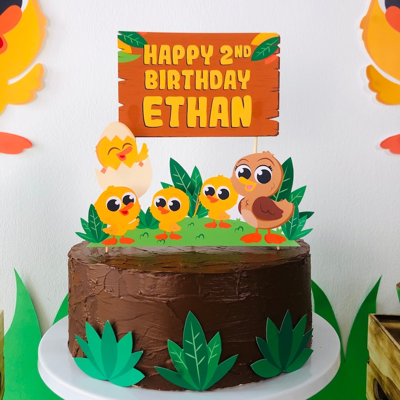 May include: A chocolate cake decorated with a brown duck and yellow chicks, with a sign that reads "Happy 2nd Birthday Ethan".
