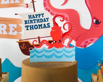 May include: A brown cake with a blue and white octopus cake topper. The topper says "Happy Birthday Thomas".