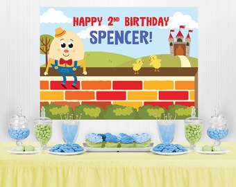 Puede incluir: Una mesa de decoración para una fiesta de cumpleaños con un esquema de color azul y verde. El telón de fondo presenta un personaje de dibujos animados, un castillo y el texto "Happy 2nd Birthday Spencer!" 