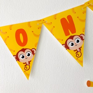 May include: Yellow triangle banner with the letter "O" and a cartoon monkey on a yellow background with a banana pattern. The next triangle has the letter "N" and a cartoon monkey on a yellow background with a banana pattern.