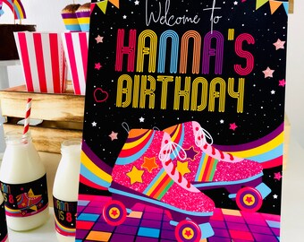 May include: A black and white birthday sign with rainbow colored text that says "Welcome to Hanna's Birthday". The sign features a pair of pink roller skates with rainbow stripes and yellow stars on a black and purple checkered background.