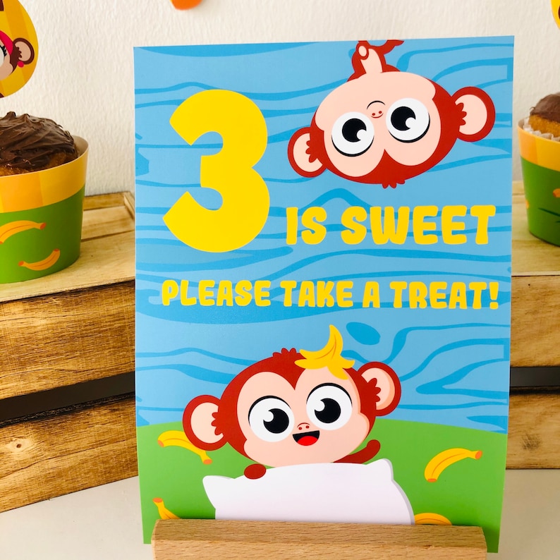 May include: A blue and green birthday party sign with a yellow number 3 and a cartoon monkey. The sign says "3 is sweet, please take a treat!"