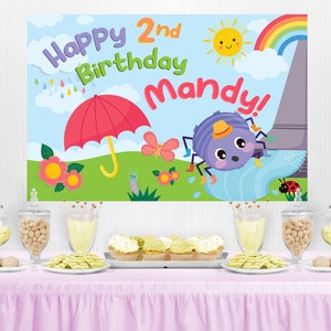 May include: A colorful birthday party backdrop with a cartoon spider, a red umbrella, a rainbow, and the text "Happy 2nd Birthday Mandy!"