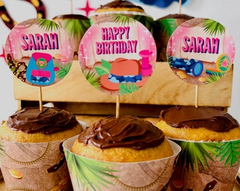 May include: A set of cupcake toppers with a jungle theme. The toppers feature a pink background with green leaves and a brown treasure chest. The text "Happy Birthday" and "Sarah" are featured on the toppers.