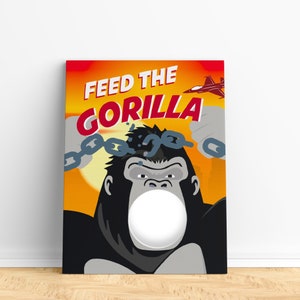 Op de afbeelding: Een spelbord met een cartoon-gorilla die zich bevrijdt van kettingen. De gorilla heeft een grote, witte cirkel voor zijn mond, waar een gezicht in geplaatst kan worden. De tekst "Feed the Gorilla" staat bovenaan het bord.