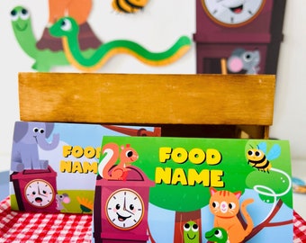 May include: Three colorful printable food name cards with a cartoon clock, animal, and the text "Food Name".