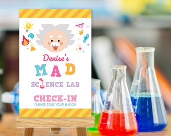 May include: A colorful sign with a cartoon scientist and the text "Denise's MAD SCIENCE LAB CHECK-IN PLEASE TAKE YOUR BADGE" on a wooden easel. The sign is in front of a table with beakers filled with colored liquids.