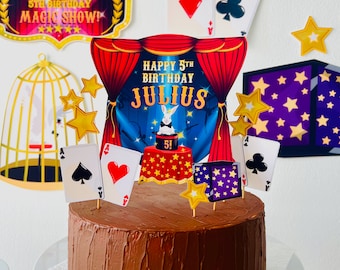May include: A chocolate cake decorated with a red and blue magic show theme. The cake is topped with a sign that says "Happy 5th Birthday Julius" and playing cards. 