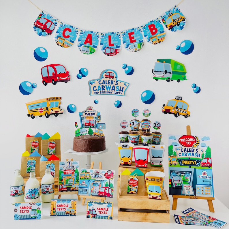 A birthday party table setting with a car wash theme. Decorations include a banner with the name "Caleb", a cake with a carwash sign, and various party favours with a carwash theme. The table is decorated with a wooden crate and a small easel with a sign that says "Welcome to Caleb's Carwash Party!"