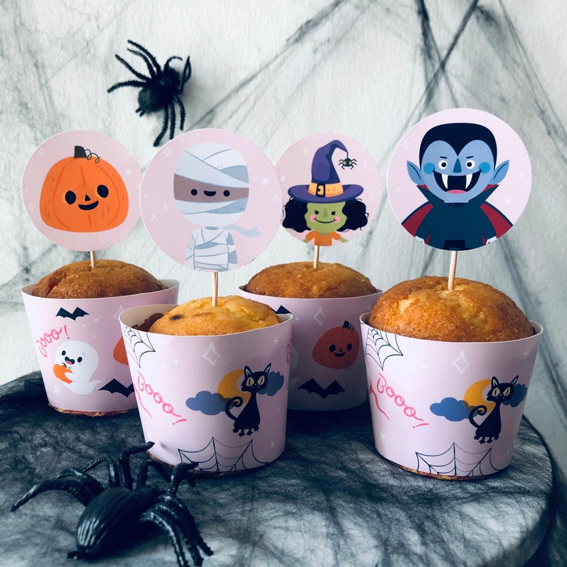 May include: Six Halloween-themed cupcake toppers with images of a pumpkin, a mummy, a witch, a vampire, a ghost, and a cat. The toppers are placed on top of cupcakes with white frosting and colorful sprinkles.