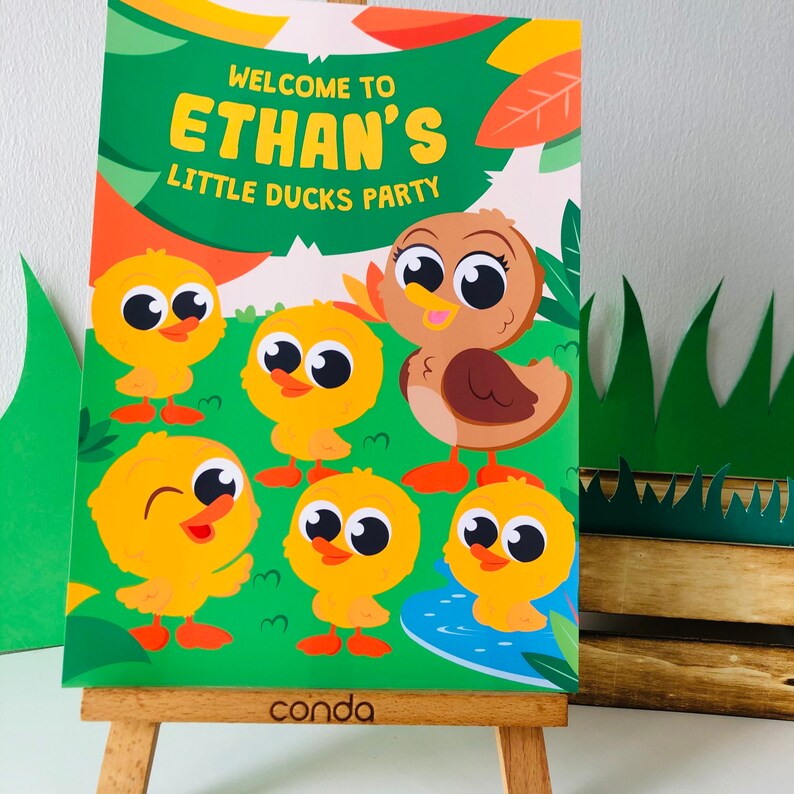 May include: A green and orange welcome sign with the text "Welcome to Ethan's Little Ducks Party". The sign features a brown duck and five yellow ducklings with big eyes.
