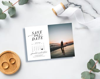 May include: Save the date card with a calendar featuring June 2023 with a heart marking the date. The card also includes a photo of a couple standing on a beach at sunset. The text reads "Save Our Date" and "Jennie and Eric are getting married!"
