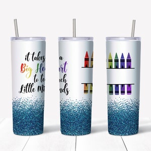 May include: Three stainless steel tumblers with lids and straws. The tumbler on the left has a blue glitter bottom and says "It takes a Big Heart to teach Little Minds". The middle tumbler has a rainbow of crayons and the text "A Heart to Teach Little Minds". The tumbler on the right has a row of rainbow crayons.